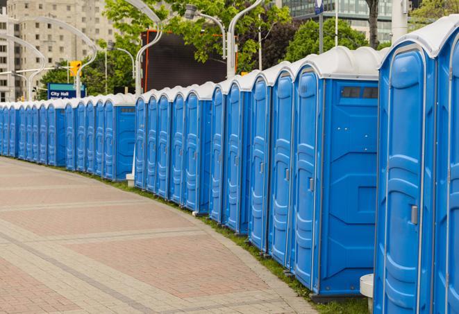 a row of portable restrooms set up for a large athletic event, allowing participants and spectators to easily take care of their needs in Danbury CT